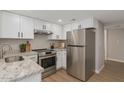 Well-lit kitchen featuring stainless steel appliances, white cabinets, and granite countertops at 7930 E Camelback Rd # 506, Scottsdale, AZ 85251
