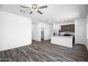 Spacious open-concept living space with wood-look flooring and a view into the kitchen area at 24636 W St Catherine Ave, Buckeye, AZ 85326