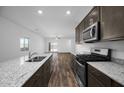 Open-concept kitchen with island, stainless steel appliances, granite counters, flowing into the living area at 24621 W Alta Vista Rd, Buckeye, AZ 85326