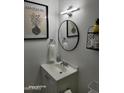 Well-lit bathroom featuring a round mirror and decorative accents at 4032 W Reade Ave, Phoenix, AZ 85019