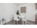 Clean dining area showcasing a glass-top table with white chairs, art, and wood-look floors in a bright setting at 4032 W Reade Ave, Phoenix, AZ 85019