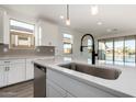 Kitchen island with sink, black faucet, and view of backyard at 40532 W Wade Dr, Maricopa, AZ 85138