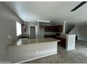 Open kitchen with granite countertop bar, dark wood cabinets, and tile flooring at 23671 W Wayland Dr, Buckeye, AZ 85326