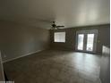 Bright living room featuring tile floors, a ceiling fan, and glass doors leading to the pool at 23671 W Wayland Dr, Buckeye, AZ 85326