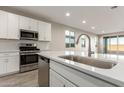 Modern kitchen with white cabinets, quartz countertops, and a stylish sink at 21641 N Daniel Dr, Maricopa, AZ 85138