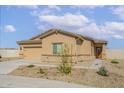 Tan single-story home featuring a two-car garage and neutral desert landscaping at 680 W Crowned Dove Trl, Casa Grande, AZ 85122
