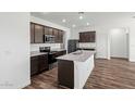 Modern kitchen featuring granite countertops, stainless appliances, and dark wood cabinets at 680 W Crowned Dove Trl, Casa Grande, AZ 85122