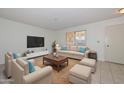 Bright living room with modern furniture, tile floors, and a neutral color palette for a cozy and inviting atmosphere at 10802 W Cameo Dr, Sun City, AZ 85351