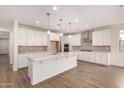 Modern kitchen with white cabinets, center island, stainless steel appliances, and pendant lighting at 20254 W Hollyhock St, Buckeye, AZ 85396