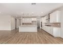 Bright, open kitchen featuring stainless steel appliances, a center island, and wooden floors throughout at 20254 W Hollyhock St, Buckeye, AZ 85396