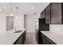 Modern kitchen island with white countertop and dark cabinets at 40519 W Wade Dr, Maricopa, AZ 85138