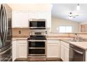 Updated kitchen featuring stainless steel appliances, neutral countertops, and ample storage space for modern living at 10649 W Monte Vista Rd, Avondale, AZ 85392