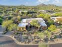 An aerial view of the home surrounded by desert landscaping and mountain views at 8167 E Sand Flower Dr, Scottsdale, AZ 85266