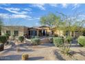 Home's exterior features desert landscaping and a welcoming entrance with curtains at 8167 E Sand Flower Dr, Scottsdale, AZ 85266