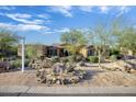 Home's exterior shows desert landscaping, mature trees, and signage at 8167 E Sand Flower Dr, Scottsdale, AZ 85266