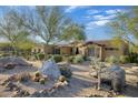 Charming home with desert landscaping featuring rocks, cacti, and mature trees at 8167 E Sand Flower Dr, Scottsdale, AZ 85266