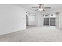 Bright living room with carpet, ceiling fan, sliding glass door, and stainless refrigerator at 2610 W Berridge Ln # C115, Phoenix, AZ 85017