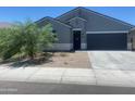 Inviting single-story home featuring a two-car garage, neutral colors, and desert landscaping in front at 1157 W Paradise Way, Casa Grande, AZ 85122