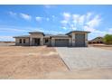 A modern single-story home with a spacious driveway and desert landscaping under a bright blue sky at 1101 E Dolores Rd, Phoenix, AZ 85086