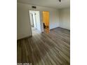 Open living area with wood-look floors, hallway, and bathroom access at 1091 N 84Th Pl, Scottsdale, AZ 85257