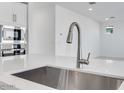 Close-up of a stainless steel kitchen sink with a modern faucet and quartz countertops at 17632 W Oregon Ave, Litchfield Park, AZ 85340