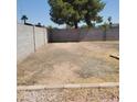 Spacious backyard featuring a large, flat dirt area, bordered by block walls and desert landscaping at 3222 W Wagoner Rd, Phoenix, AZ 85053