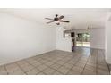 Bright living room with tile flooring, ceiling fan, and an open floor plan to the kitchen and backyard access at 3222 W Wagoner Rd, Phoenix, AZ 85053