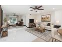 Bright living room with sleek white floors, ceiling fans, area rugs, and views to an additional sitting area at 4020 W Anderson Dr, Glendale, AZ 85308