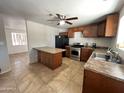 Kitchen with island, stainless steel appliances, and wood cabinets at 12438 N 111Th Ave, Youngtown, AZ 85363