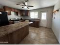 View of kitchen with wood cabinets and tiled floor at 12438 N 111Th Ave, Youngtown, AZ 85363