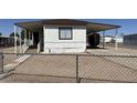 Charming mobile home with covered parking, a ramp, and a fenced yard at 8730 E Dolega Ave, Mesa, AZ 85208