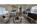 Bright living room showcasing an open floor plan with a kitchen, dining area, and neutral-toned furniture at 8730 E Dolega Ave, Mesa, AZ 85208