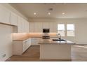 Modern kitchen with white cabinets, island, and herringbone backsplash at 17990 W Long Lake Rd, Goodyear, AZ 85338