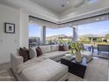 Living room with neutral sectional, dark wood coffee table, and large sliding doors to the outdoor patio at 37200 N Cave Creek Rd # 2110, Scottsdale, AZ 85262