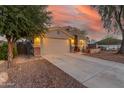 House exterior with driveway, landscaping, and sunset view at 3932 N Silver King Ln, Casa Grande, AZ 85122