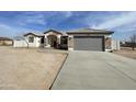 Single story home with gray garage door and stone accents at 12827 S Hermit Rd, Buckeye, AZ 85326