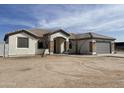 Single-story home with gray garage door and stone accents at 12827 S Hermit Rd, Buckeye, AZ 85326