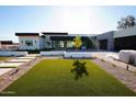 Modern home showcasing green lawn, a stone driveway, and clean, modern landscaping at 12232 N 65Th Pl, Scottsdale, AZ 85254