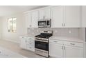 Modern kitchen with stainless steel appliances and white cabinets at 11519 S 50Th Ave, Laveen, AZ 85339