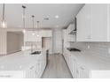 Spacious kitchen featuring white cabinets, stainless steel appliances, subway tile backsplash and oversized island at 19655 E Estrella Rd, Queen Creek, AZ 85142