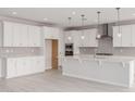 Bright kitchen features white cabinets, stainless steel appliances, subway tile backsplash and a large island at 19655 E Estrella Rd, Queen Creek, AZ 85142