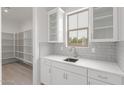 Kitchen featuring white cabinets, a stylish backsplash, stainless steel sink and a convenient pantry at 21921 S 197Th St, Queen Creek, AZ 85142