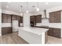 Modern kitchen boasts dark cabinets, white subway tile backsplash, stainless steel appliances, and a large center island at 17225 W Calle Lejos --, Surprise, AZ 85387