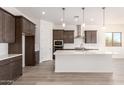Modern kitchen boasts dark cabinets, white subway tile backsplash, stainless steel appliances, and a large center island at 17225 W Calle Lejos --, Surprise, AZ 85387