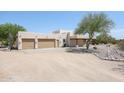 Two-car garage and side view of a stucco home with desert landscaping at 19927 W Meadowbrook Ave, Litchfield Park, AZ 85340