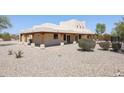 Back view of stucco home with covered patio and desert landscaping at 19927 W Meadowbrook Ave, Litchfield Park, AZ 85340