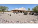 Back view of stucco home with covered patio and desert landscaping at 19927 W Meadowbrook Ave, Litchfield Park, AZ 85340