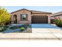 Single-story house with a brown garage door and well-maintained landscaping at 12179 E Sereno Rd, Gold Canyon, AZ 85118