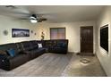 Comfortable living room features a leather sectional sofa, neutral carpet, and plenty of natural light at 45737 W Ranch Rd, Maricopa, AZ 85139