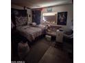 Showing a cluttered bedroom with a bed, crib, and decorations at 3802 N 79Th Ave, Phoenix, AZ 85033